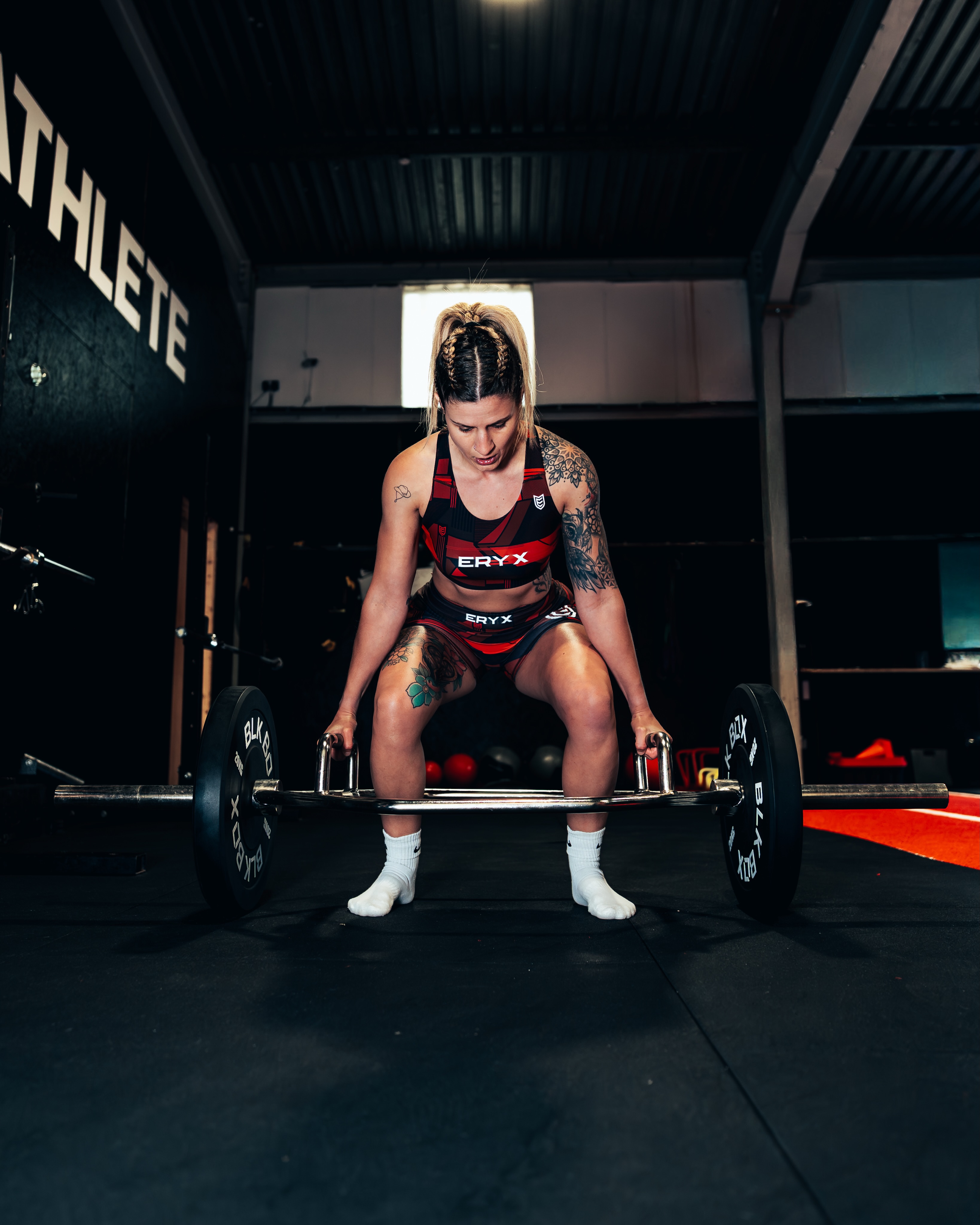 Athlete setting up a heavy trap bar deadlift beneath the Inner Athlete wall lettering